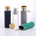 Botella de agua de 1000 ml de nuevo diseño de vidrio de color con tapa y funda de bambú